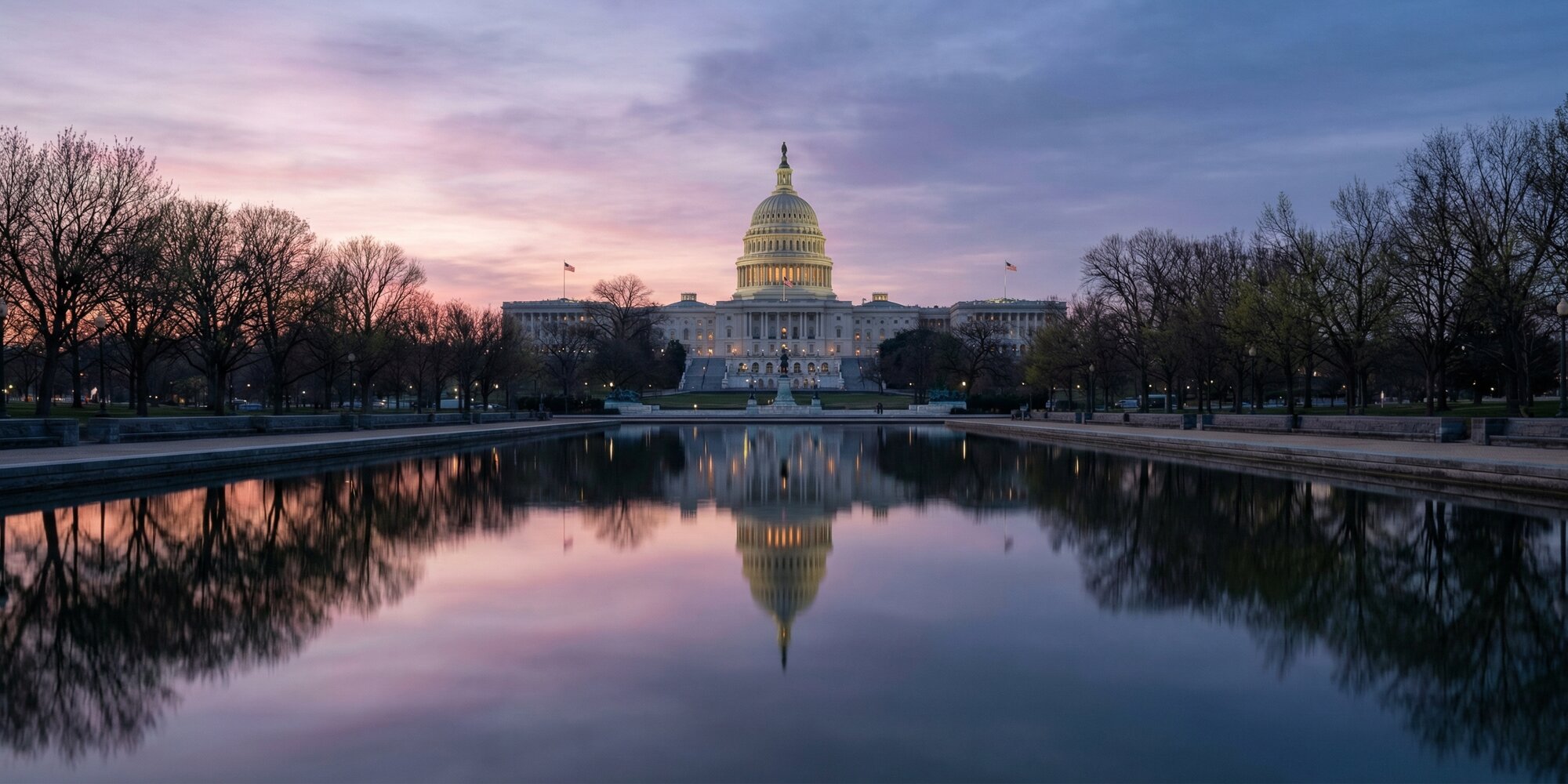 The U.S. Capitol dome reflected in the Capitol Reflecting Pool at dawn, with a pink and blue morning sky